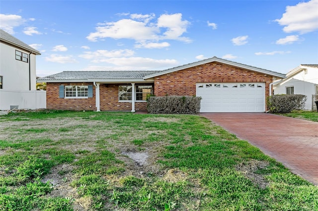 ranch-style house with driveway, fence, a front yard, an attached garage, and brick siding