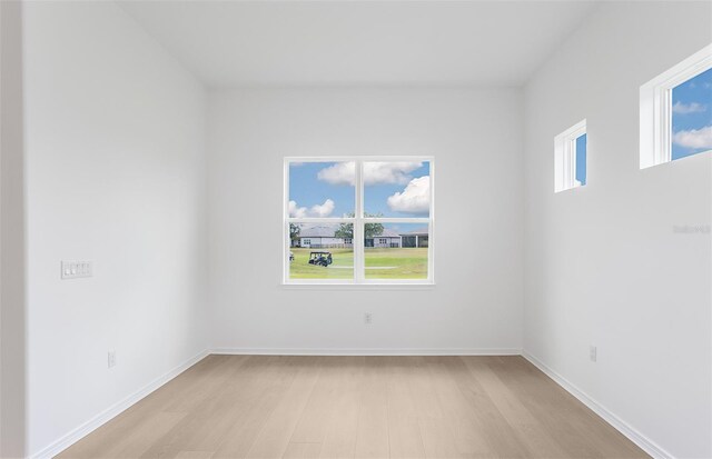 spare room featuring light wood-style floors and baseboards