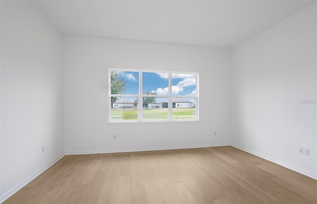 empty room featuring baseboards and light wood-type flooring