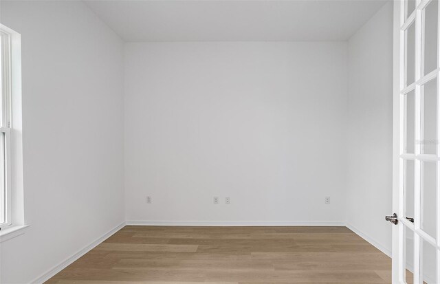empty room featuring baseboards and light wood-style flooring