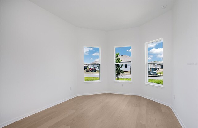 unfurnished room with light wood-style floors and baseboards