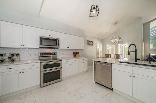 2206 Green Oaks Ln, Tampa, FL 33612 - kitchen featuring vaulted ceiling, stainless steel appliances, marble finish floor, a sink, and a notable chandelier