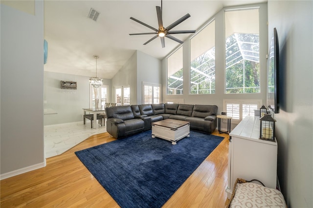 2206 Green Oaks Ln, Tampa, FL 33612 - living area featuring high vaulted ceiling, baseboards, ceiling fan with notable chandelier, visible vents, and light wood-style floors
