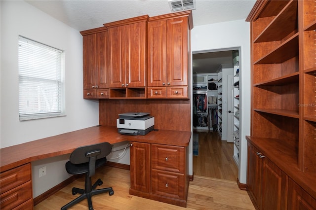 2206 Green Oaks Ln, Tampa, FL 33612 - office featuring a textured ceiling, built in study area, light wood-style flooring, and visible vents
