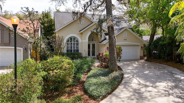 2206 Green Oaks Ln, Tampa, FL 33612 - traditional home featuring driveway, french doors, roof with shingles, stucco siding, and an attached garage