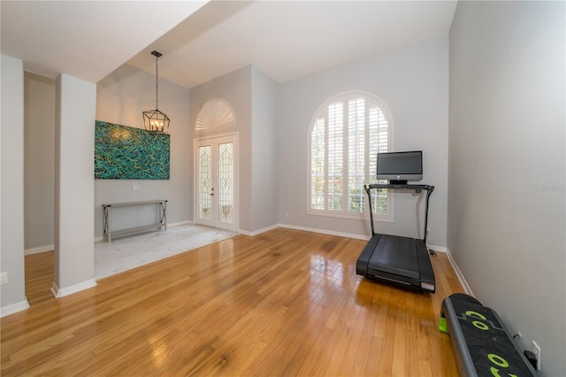 2206 Green Oaks Ln, Tampa, FL 33612 - exercise area featuring baseboards, a notable chandelier, french doors, and light wood-type flooring