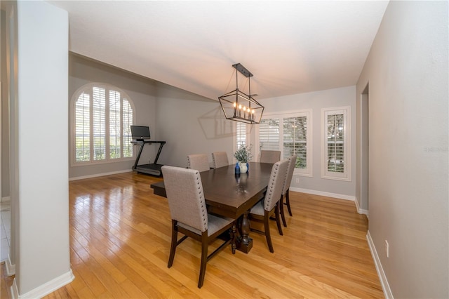 2206 Green Oaks Ln, Tampa, FL 33612 - dining space with light wood finished floors, baseboards, and a chandelier