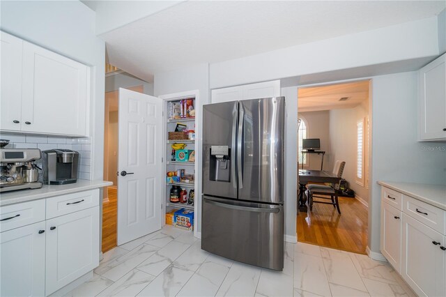 2206 Green Oaks Ln, Tampa, FL 33612 - kitchen with marble finish floor, stainless steel fridge with ice dispenser, white cabinets, and light countertops