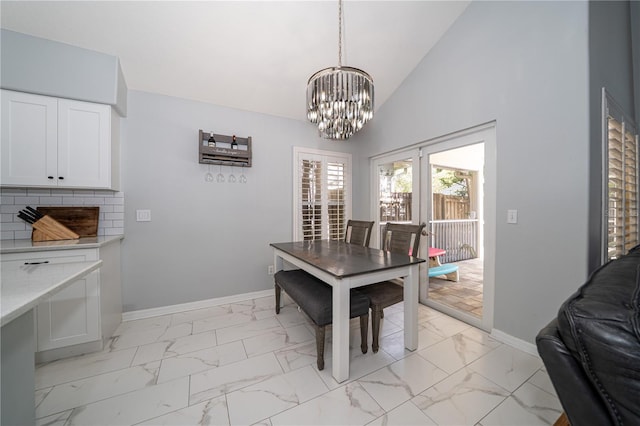 2206 Green Oaks Ln, Tampa, FL 33612 - dining space featuring baseboards, marble finish floor, high vaulted ceiling, and a notable chandelier