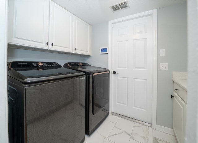 2206 Green Oaks Ln, Tampa, FL 33612 - laundry room featuring independent washer and dryer, baseboards, marble finish floor, visible vents, and cabinet space