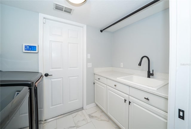 2206 Green Oaks Ln, Tampa, FL 33612 - washroom with a sink, washing machine and clothes dryer, marble finish floor, visible vents, and cabinet space