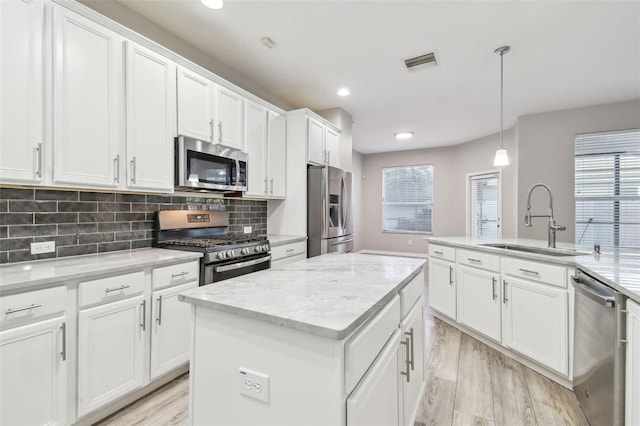 12304 Silton Peace Dr, Riverview, FL 33579 - kitchen featuring a sink, stainless steel appliances, light wood-type flooring, and a center island