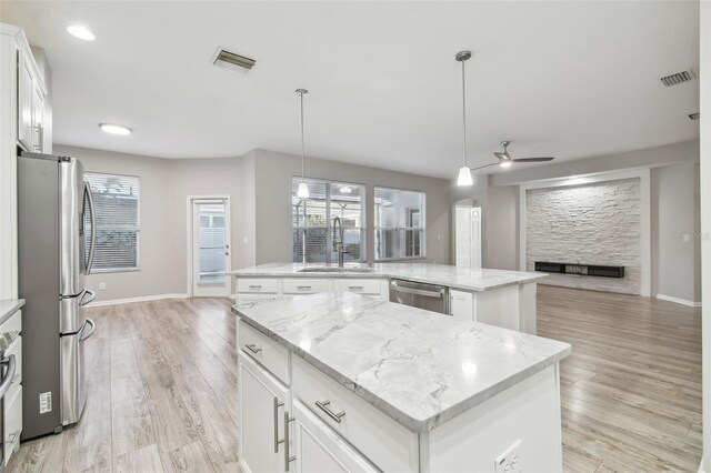 12304 Silton Peace Dr, Riverview, FL 33579 - kitchen with open floor plan, an island with sink, appliances with stainless steel finishes, a ceiling fan, and a sink