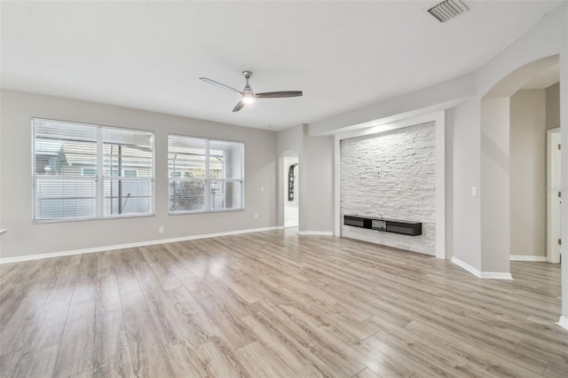 12304 Silton Peace Dr, Riverview, FL 33579 - unfurnished living room with visible vents, baseboards, wood finished floors, arched walkways, and a ceiling fan