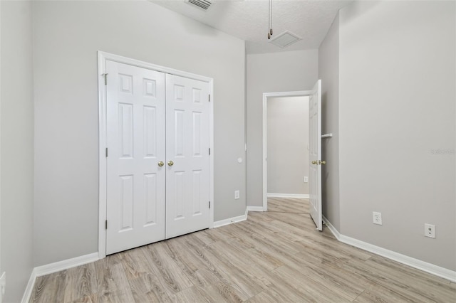 12304 Silton Peace Dr, Riverview, FL 33579 - unfurnished bedroom with a closet, visible vents, light wood-style flooring, and baseboards