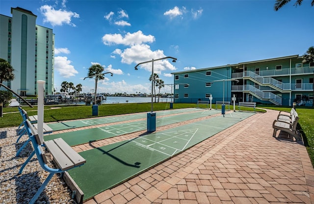 6201 2nd St E Unit 89, St Pete Beach, FL 33706 - view of home's community featuring shuffleboard, a water view, and a lawn