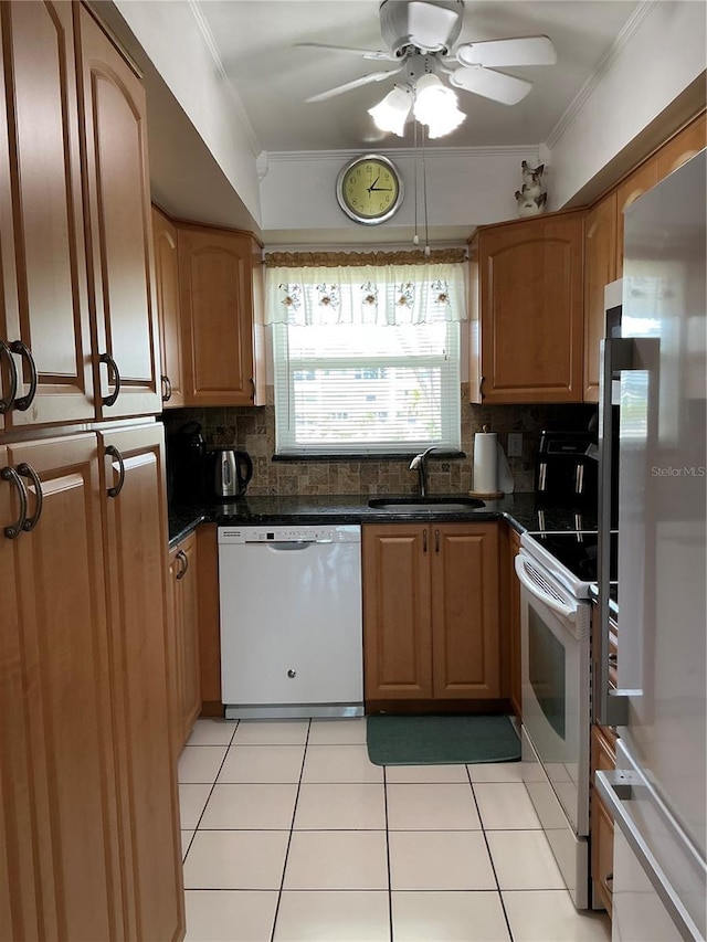 6201 2nd St E Unit 89, St Pete Beach, FL 33706 - kitchen with crown molding, dark countertops, a sink, decorative backsplash, and white appliances