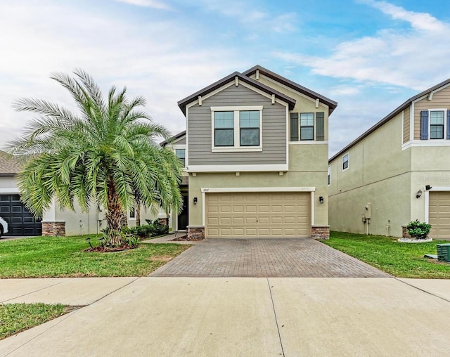 view of front of house with decorative driveway, a garage, a front lawn, and stucco siding