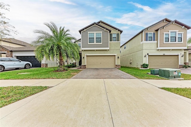 view of front of home featuring a garage, a front yard, driveway, and stucco siding