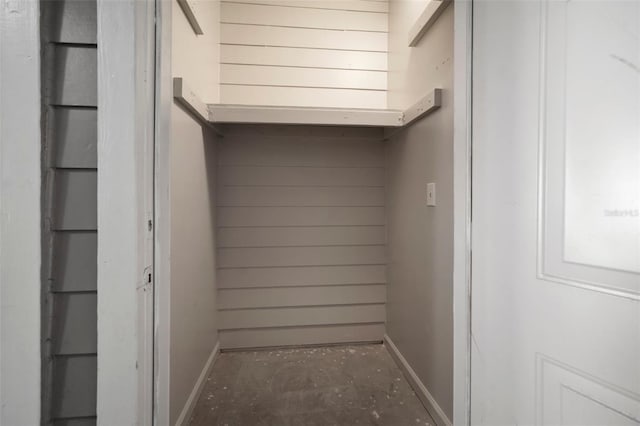 details featuring wooden walls, baseboards, and concrete flooring