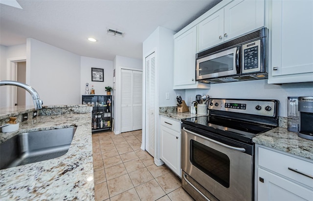 700 S Harbour Island Blvd Unit 404, Tampa, FL 33602 - kitchen with light tile patterned floors, visible vents, a sink, stainless steel appliances, and white cabinetry