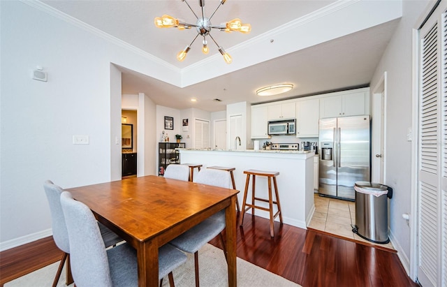 700 S Harbour Island Blvd Unit 404, Tampa, FL 33602 - dining room featuring baseboards, an inviting chandelier, crown molding, and light wood finished floors
