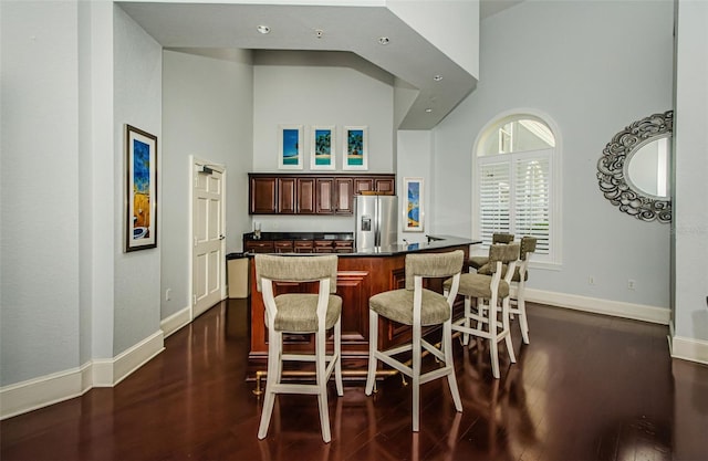 700 S Harbour Island Blvd Unit 404, Tampa, FL 33602 - kitchen with dark countertops, a high ceiling, a breakfast bar area, stainless steel fridge with ice dispenser, and dark wood-style flooring