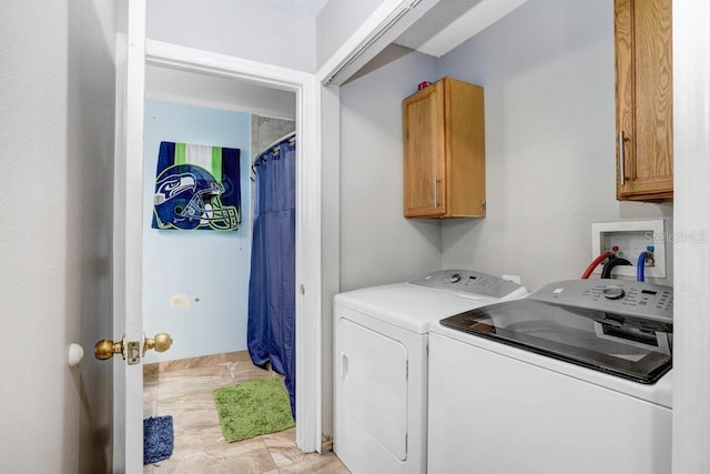 laundry room with washing machine and clothes dryer and cabinet space