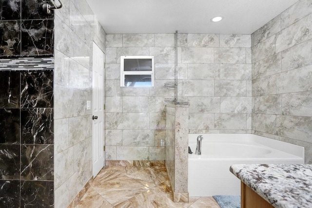 bathroom featuring vanity, a walk in shower, and a bath