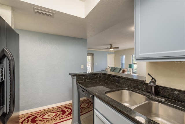 720 Lyndhurst St Unit 1121, Dunedin, FL 34698 - kitchen featuring a sink, black appliances, dark stone counters, ceiling fan, and a textured wall