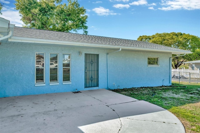 7323 Andre Dr, Zephyrhills, FL 33541 - rear view of house with stucco siding, a shingled roof, fence, and a patio area