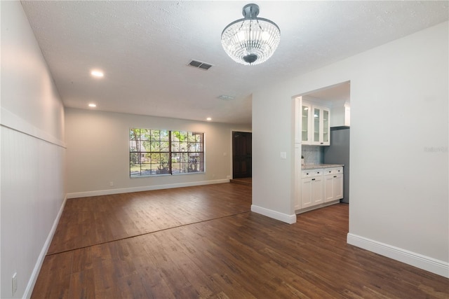 2715 Willow Oaks Dr, Valrico, FL 33594 - unfurnished living room with dark wood-style flooring, baseboards, recessed lighting, and a chandelier