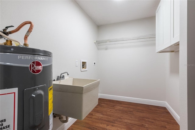 2715 Willow Oaks Dr, Valrico, FL 33594 - laundry area featuring electric water heater, cabinet space, wood finished floors, baseboards, and hookup for a washing machine