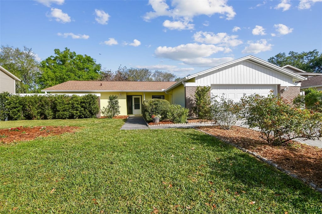 single story home featuring a front yard and an attached garage
