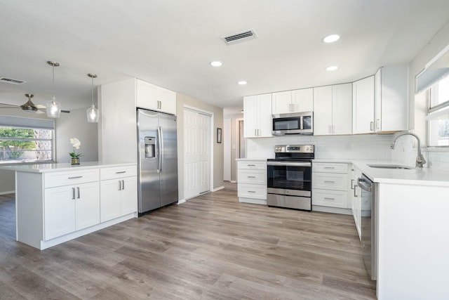 kitchen featuring tasteful backsplash, visible vents, stainless steel appliances, and a sink