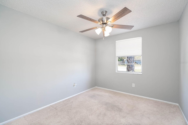 carpeted empty room with a textured ceiling, baseboards, and ceiling fan