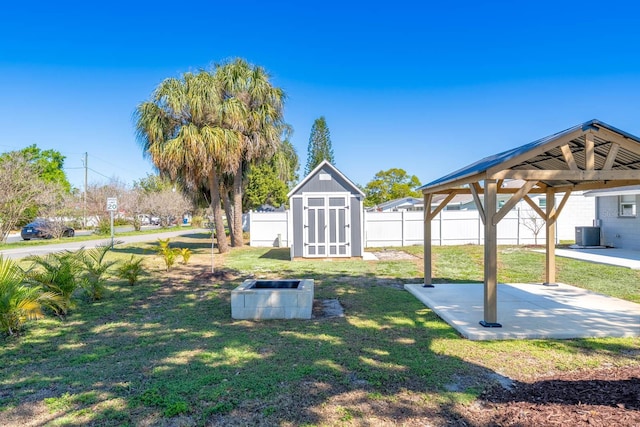 view of yard with an outbuilding, a patio, fence, a gazebo, and a storage unit