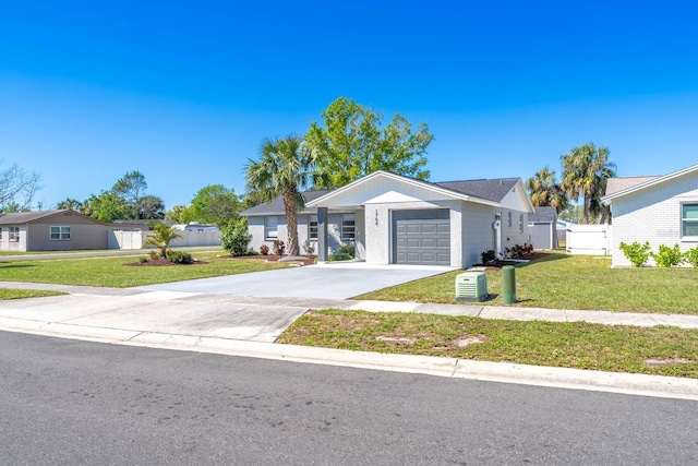 view of front of property featuring a front lawn, concrete driveway, fence, and an attached garage