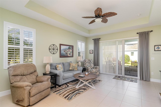 689 Chipper Dr, Sun City Center, FL 33573 - living area with a tray ceiling, baseboards, a healthy amount of sunlight, and ceiling fan