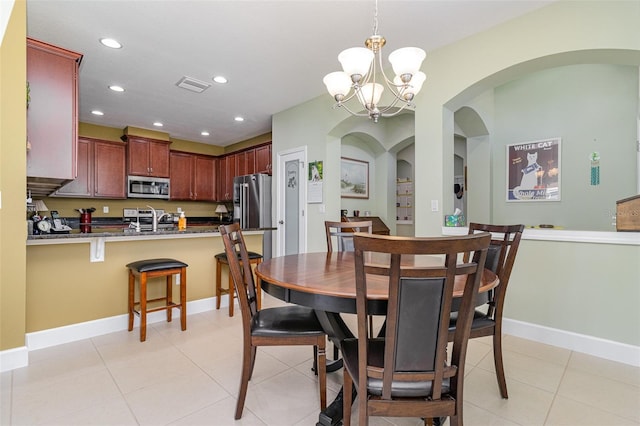 689 Chipper Dr, Sun City Center, FL 33573 - dining space featuring light tile patterned floors, visible vents, recessed lighting, arched walkways, and a chandelier