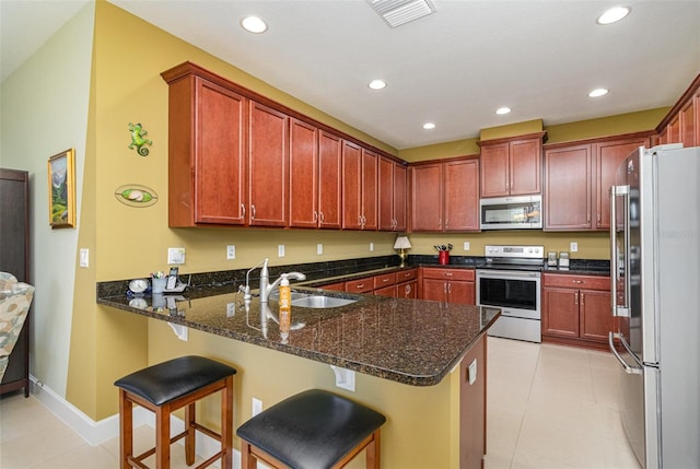 689 Chipper Dr, Sun City Center, FL 33573 - kitchen with visible vents, dark stone countertops, a peninsula, stainless steel appliances, and a sink