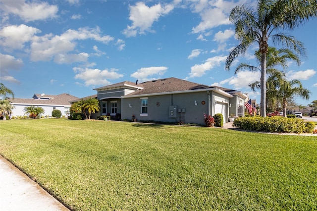 689 Chipper Dr, Sun City Center, FL 33573 - rear view of house featuring a lawn, a garage, and stucco siding