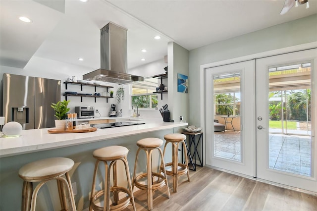 kitchen featuring stainless steel fridge with ice dispenser, light wood-style flooring, french doors, island range hood, and open shelves