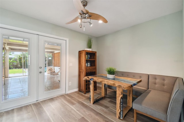 dining room featuring french doors, baseboards, light wood-style floors, and ceiling fan