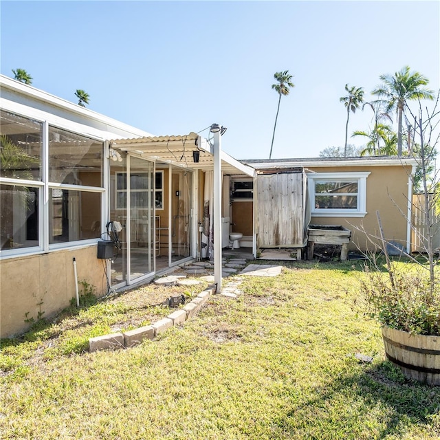 exterior space featuring stucco siding and a yard