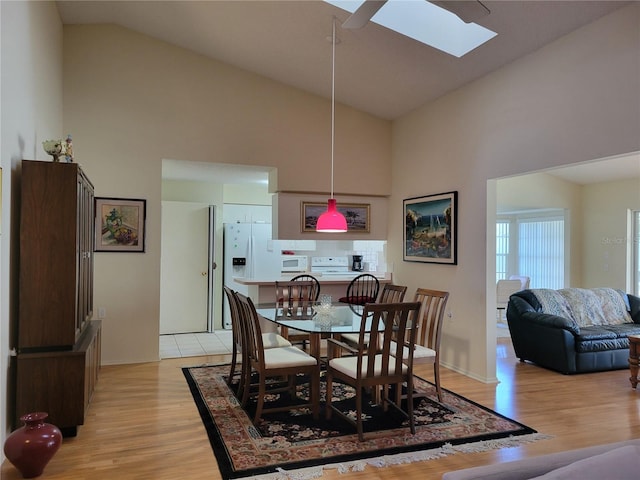7392 Meadow Brook Ln, Spring Hill, FL 34606 - dining area with high vaulted ceiling, light wood finished floors, a skylight, a ceiling fan, and baseboards