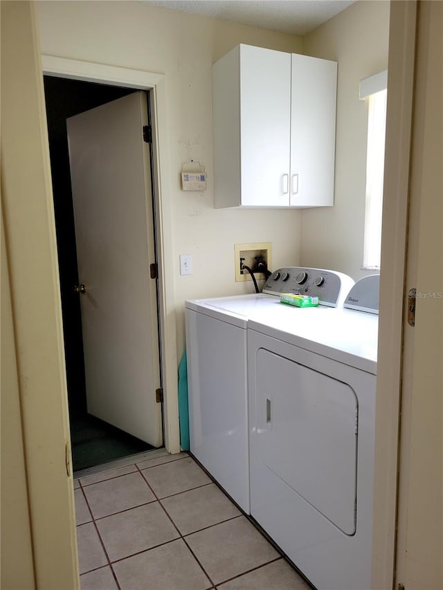 7392 Meadow Brook Ln, Spring Hill, FL 34606 - clothes washing area with independent washer and dryer, cabinet space, and light tile patterned floors