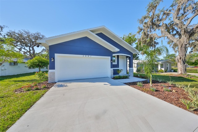 view of front facade featuring a garage, driveway, a front yard, and stucco siding