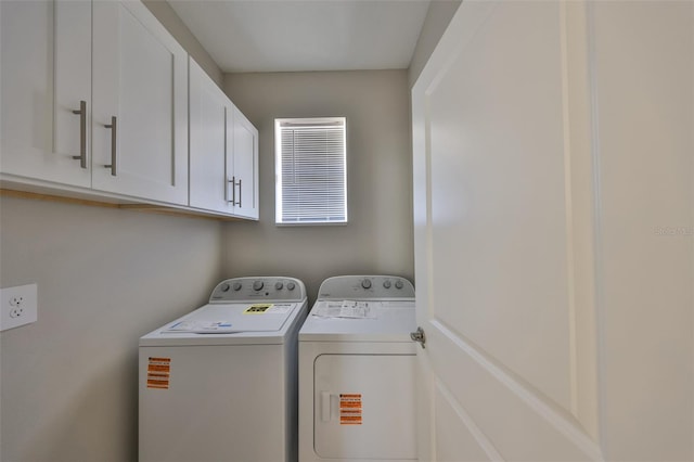 laundry room with washing machine and clothes dryer and cabinet space