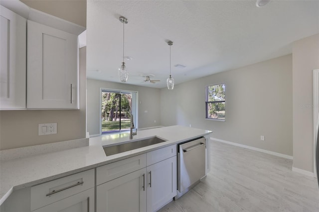 kitchen featuring hanging light fixtures, a ceiling fan, a wealth of natural light, and stainless steel dishwasher